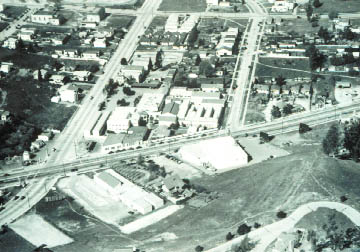 Archival black-and-white photograph of a two-storey studio building with a courtyard drive and rooftop signage lettered Walt Disney Studios, Mickey Mouse and Silly Symphony Sound Cartoons.