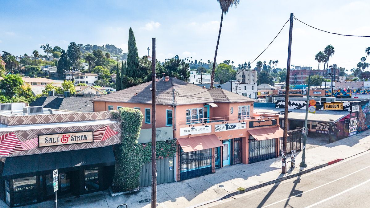 Elevated view of the terracotta building on W. Sunset Blvd., with Salt & Straw to the left and the gated right-hand storefront along the sidewalk.